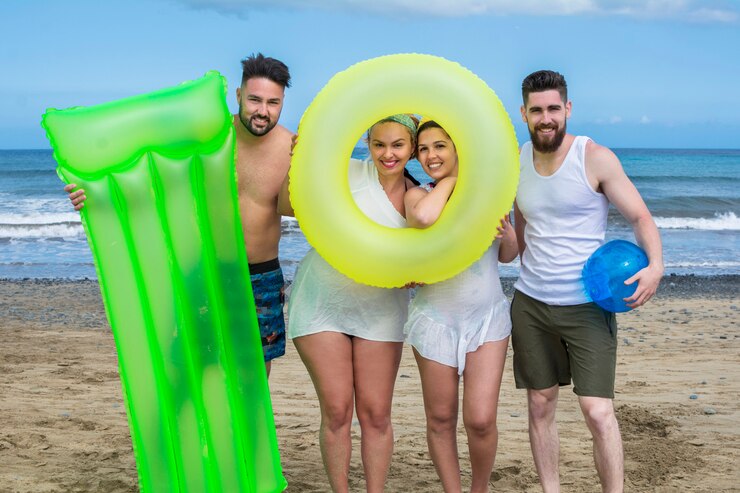 Un grupo de jóvenes amigos con flotadores de playa disfrutando de las vacaciones de verano.