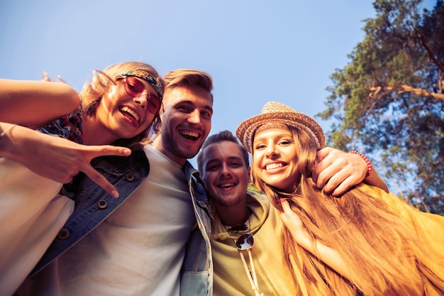 Un grupo de jóvenes amigos se hacen selfies al aire libre. Verano, vacaciones, diversión, concepto de amistad