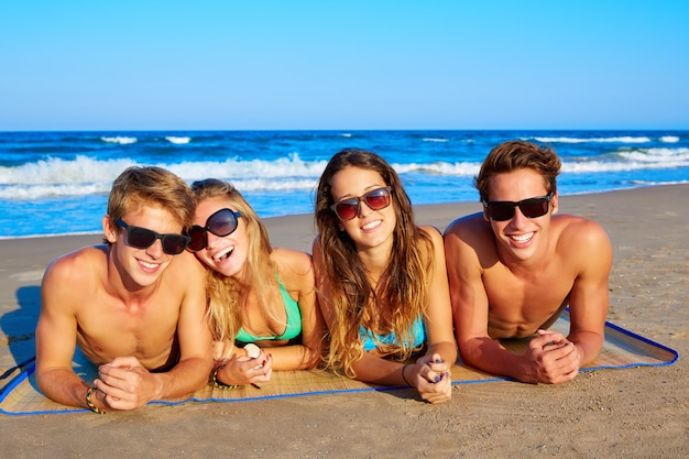 Grupo de jóvenes amigos parejas retrato en playa