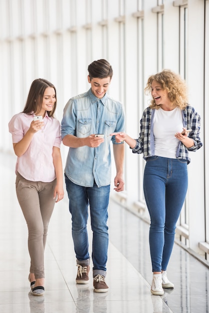 Grupo de jóvenes amigos positivos que usan sus teléfonos.