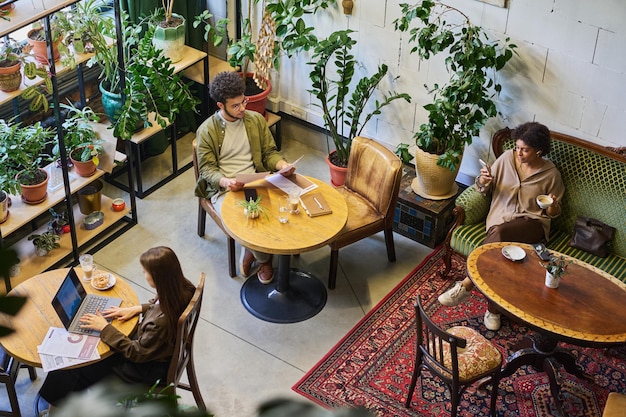 Grupo de jóvenes analistas o corredores interculturales que trabajan en un café