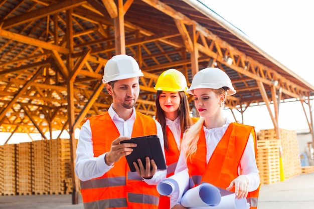 Grupo de jóvenes arquitectos e ingenieros en cascos.