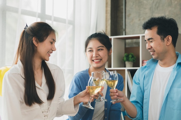 Grupo de jóvenes asiáticos tintineando copas de vino blanco fiestas de empresas emergentes fiestas de año nuevo fiestas anuales de la empresa bebidas alcohólicas fiesta de empleados de la empresa ideas de catering celebraciones