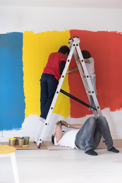 Foto un grupo de jóvenes ayuda a pintar una pared en un nuevo hogar