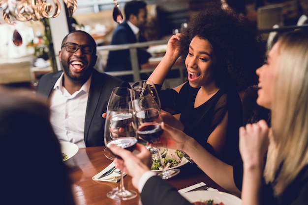 Grupo de jóvenes bebiendo vino en un restaurante.