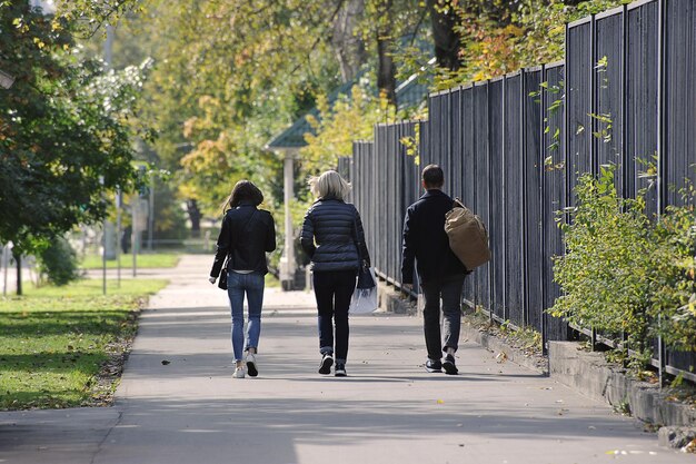 Un grupo de jóvenes caminando por la calle en un día de otoño - vista trasera