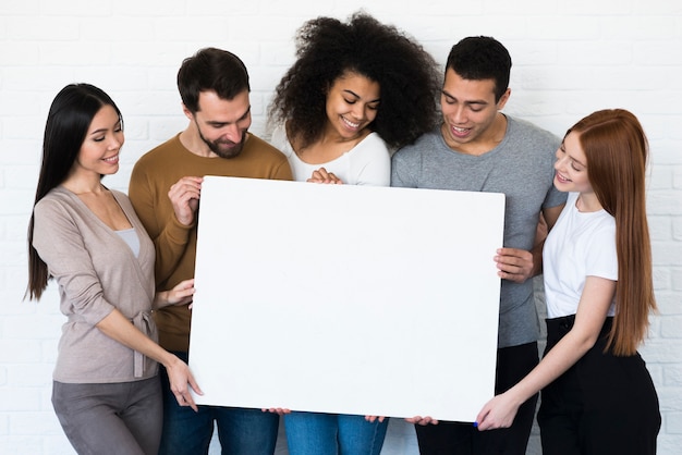 Grupo de jóvenes con un cartel juntos