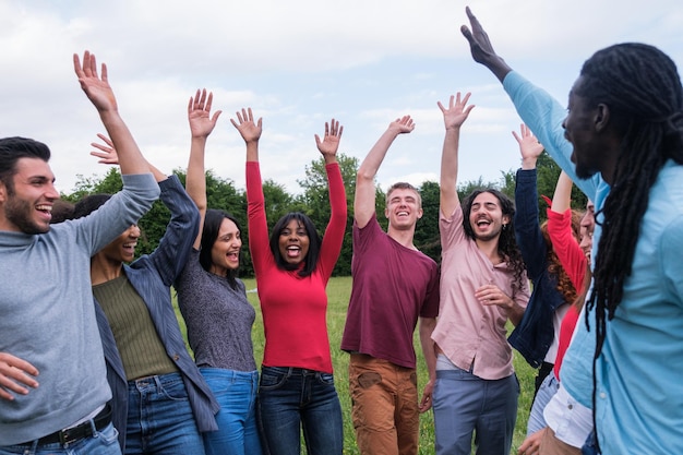 Grupo de jóvenes celebrando éxitos al aire libre estilo de vida