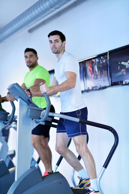 grupo de jóvenes corriendo en cintas de correr en el moderno gimnasio deportivo