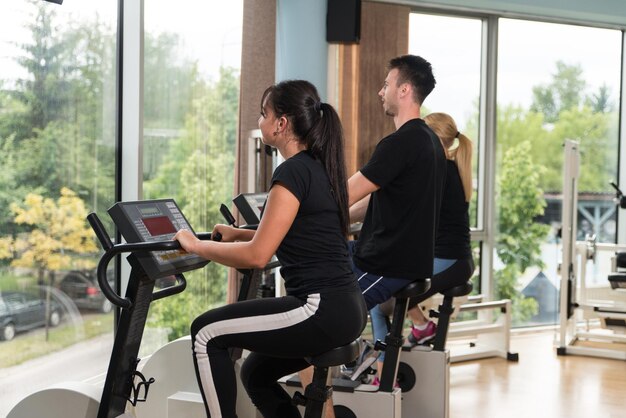 Grupo de jóvenes corriendo en cintas de correr en el moderno gimnasio deportivo