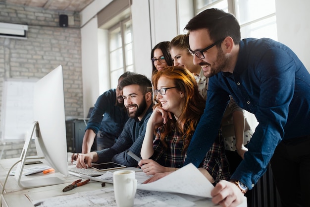 Grupo de jóvenes diseñadores que trabajan en equipo en la oficina