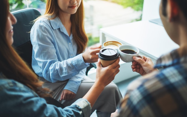 Un grupo de jóvenes disfrutó bebiendo y tintineando tazas de café en la cafetería.