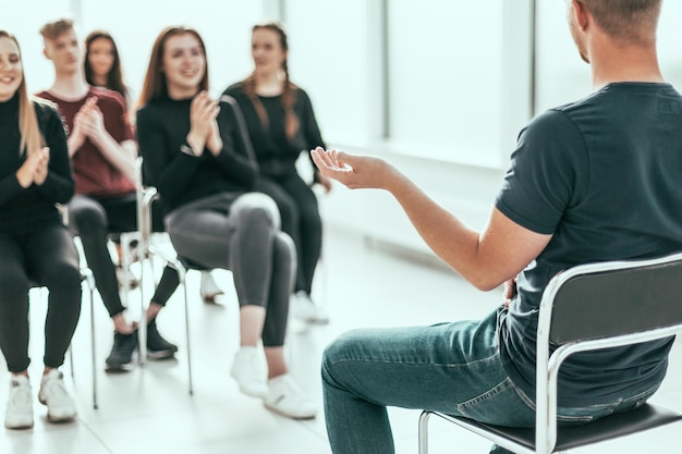 Grupo de jóvenes diversos aplaudiendo al orador empresarial. foto con espacio de copia