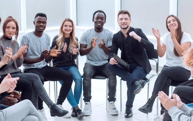 Grupo de jóvenes diversos aplaudiendo en una reunión