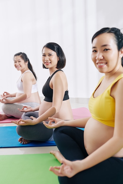 Grupo de jóvenes embarazadas asiáticas practicando yoga juntos en clase