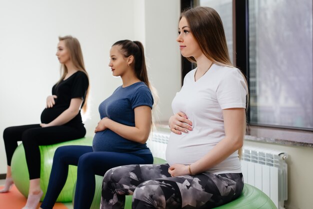 Un grupo de jóvenes embarazadas practica yoga.