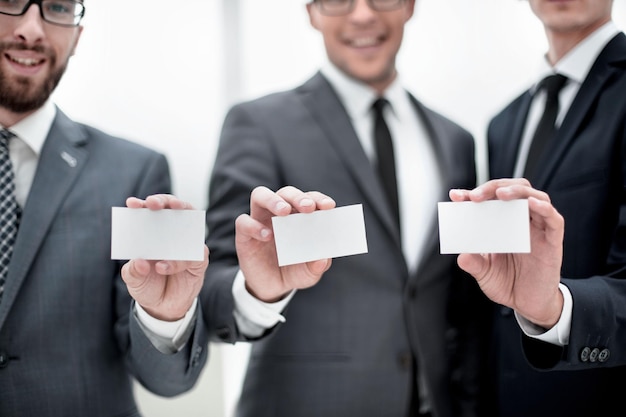 Grupo de jóvenes emprendedores mostrando sus tarjetas de visita