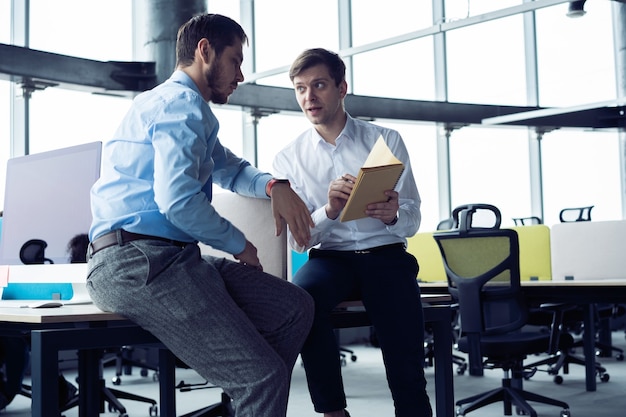 Grupo de jóvenes emprendedores que buscan una solución empresarial durante el proceso de trabajo en la oficina. Concepto de reunión de personas de negocios.