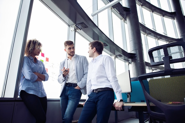 Grupo de jóvenes emprendedores que buscan una solución empresarial durante el proceso de trabajo en la oficina. Concepto de reunión de personas de negocios.