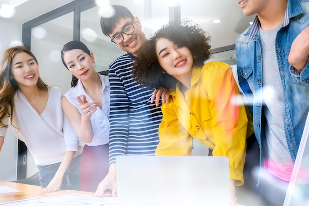 Grupo de jóvenes empresarios asiáticos creativos y felices en una oficina de reuniones de negocios El buen liderazgo y el trabajo en equipo conducen al éxito