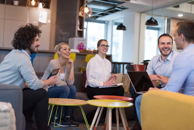 Grupo de jóvenes empresarios discutiendo plan de negocios en el edificio de oficinas de inicio moderno