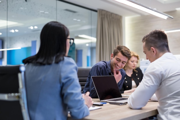 Grupo de jóvenes empresarios discutiendo plan de negocios en el edificio de oficinas de inicio moderno