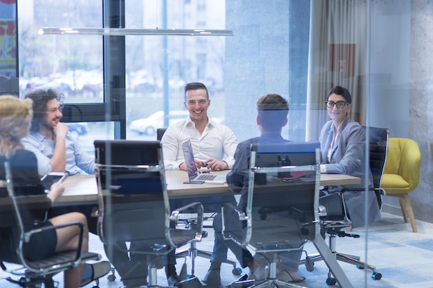 Grupo de jóvenes empresarios discutiendo plan de negocios en el edificio de oficinas de inicio moderno