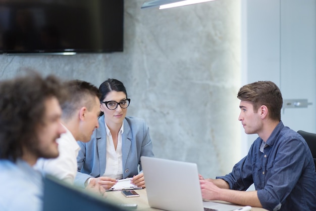 Grupo de jóvenes empresarios discutiendo plan de negocios en el edificio de oficinas de inicio moderno