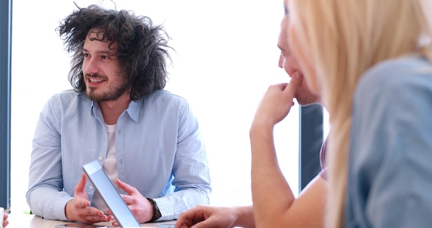 Grupo de jóvenes empresarios discutiendo plan de negocios en el edificio de oficinas de inicio moderno