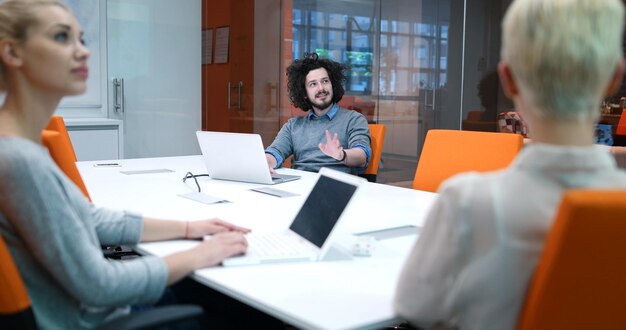 Grupo de jóvenes empresarios discutiendo plan de negocios en el edificio de oficinas de inicio moderno