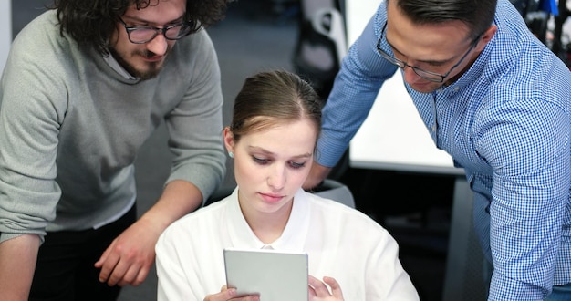 Grupo de jóvenes empresarios discutiendo plan de negocios en el edificio de oficinas de inicio moderno