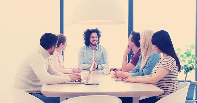 Foto grupo de jóvenes empresarios discutiendo plan de negocios en el edificio de oficinas de inicio moderno