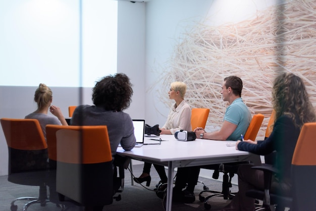 Grupo de jóvenes empresarios discutiendo el plan de negocios en el moderno edificio de oficinas de inicio nocturno