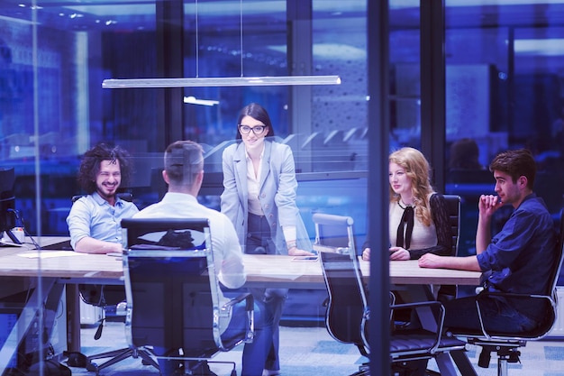 Grupo de jóvenes empresarios discutiendo un plan de negocios en un moderno edificio de oficinas de nuevas empresas