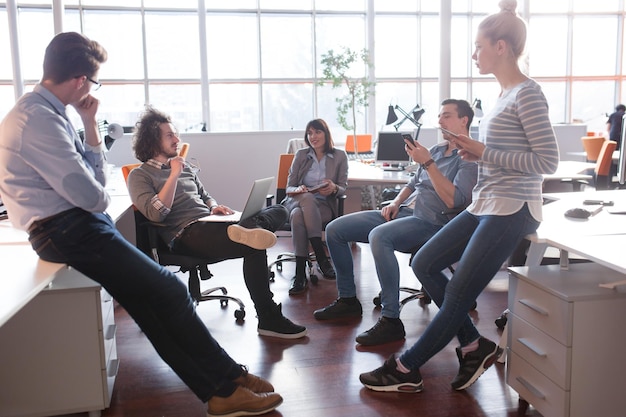 Grupo de jóvenes empresarios discutiendo el plan de negocios en la oficina