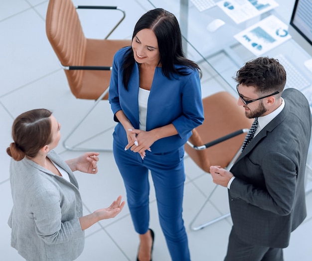 Grupo de jóvenes empresarios y empresarias discutiendo en ofic