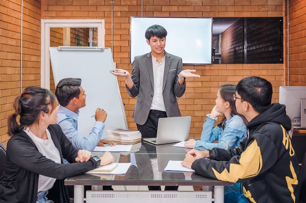 Un grupo de jóvenes empresarios está planificando las operaciones de la organización. con entrenadores expertos para dar consejos y recomendaciones