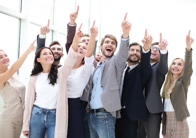 Grupo de jóvenes empresarios felices apuntando hacia arriba