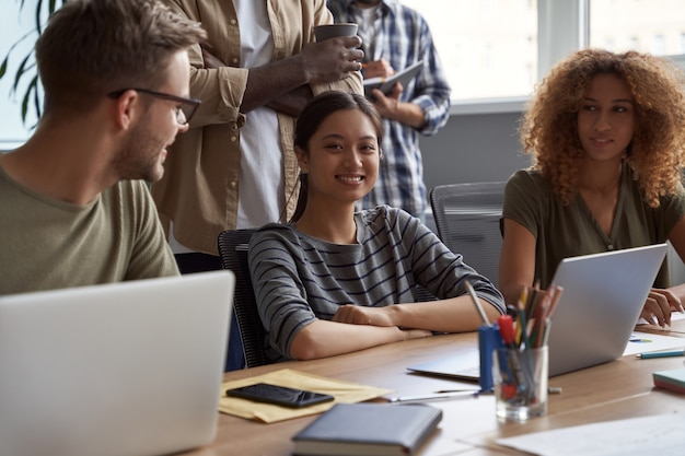 Grupo de jóvenes empresarios multiculturales trabajando juntos feliz hermosa mujer asiática sonriendo