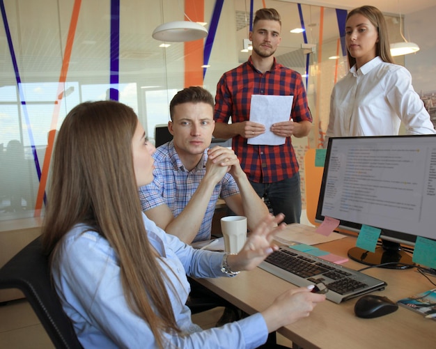 Foto grupo de jóvenes empresarios que tienen una reunión. diverso grupo de jóvenes diseñadores sonriendo durante una reunión en la oficina.