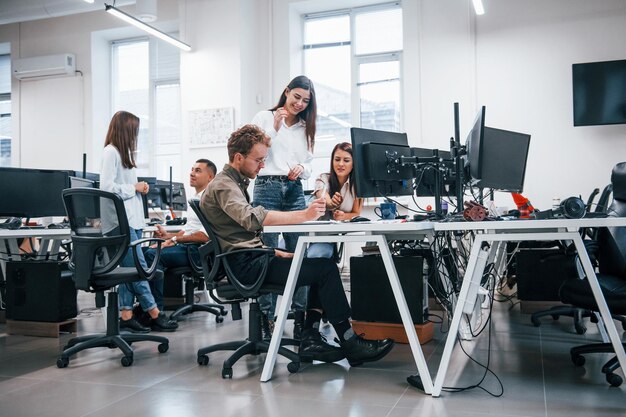 Grupo de jóvenes empresarios que trabajan con computadoras en la oficina moderna