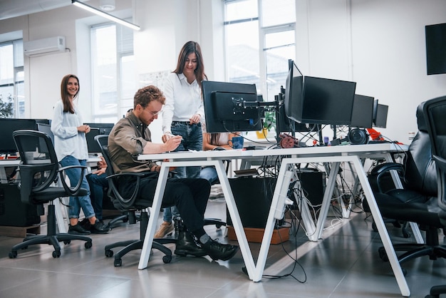 Grupo de jóvenes empresarios que trabajan con computadoras en la oficina moderna.