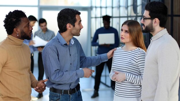 Grupo de jóvenes empresarios sonrientes discutiendo nuevas ideas