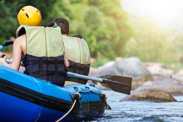 El grupo de jóvenes está transportando en balsa en un río. De cerca