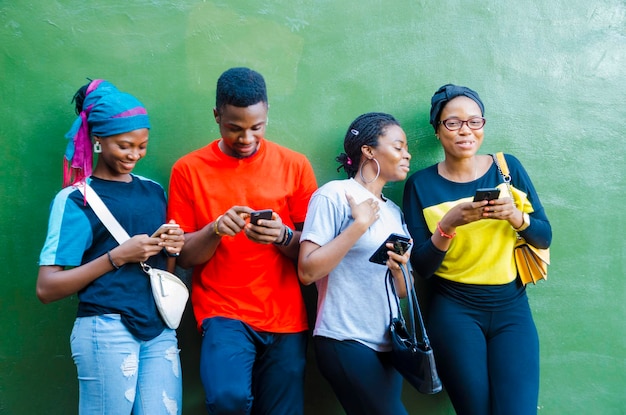 Grupo de jóvenes estudiantes africanos que se sienten entusiasmados con la sierra en su teléfono celular