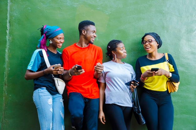 Grupo de jóvenes estudiantes africanos que se sienten entusiasmados con la sierra en su teléfono celular