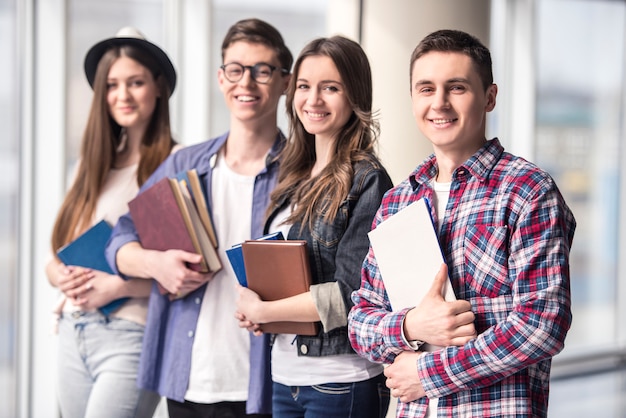 Foto grupo de jóvenes estudiantes felices en una universidad.