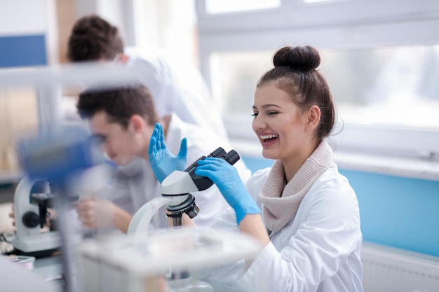 Grupo de jóvenes estudiantes de medicina investigando juntos en el laboratorio de química, trabajo en equipo de estudiantes universitarios en el interior