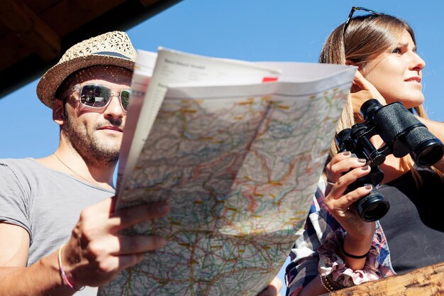 Foto grupo de jóvenes excursionistas mirando el mapa en la montaña