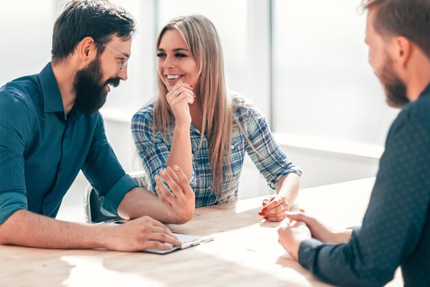 Grupo de jóvenes exitosos sentados en la mesa de negociaciones. el concepto de empleo